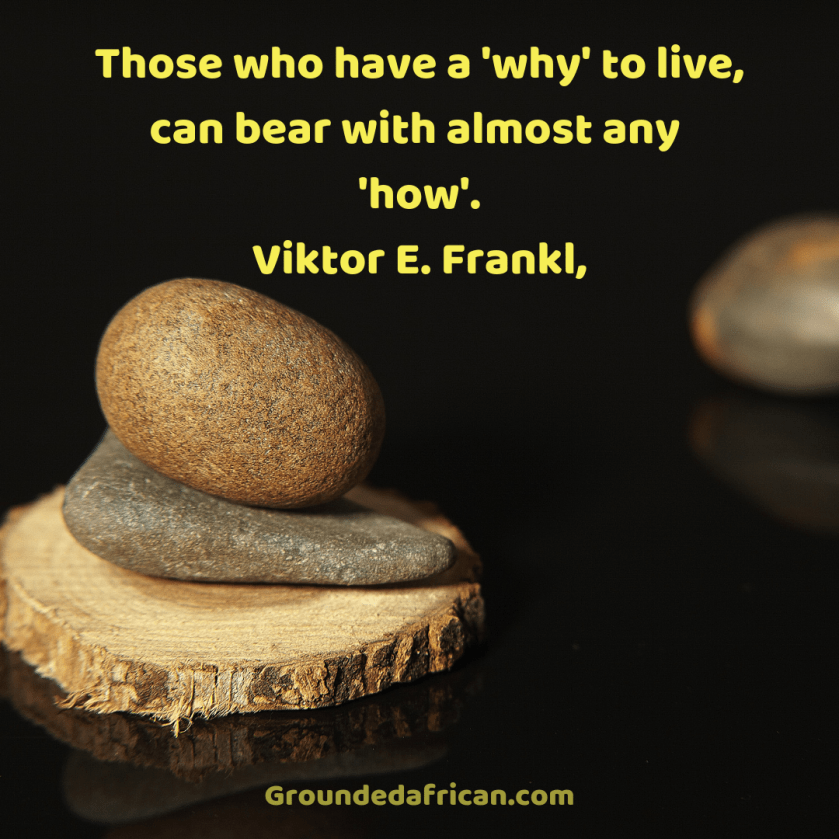Stones balancing on a piece of tree trunk. Quote by Viktor E. Frankl