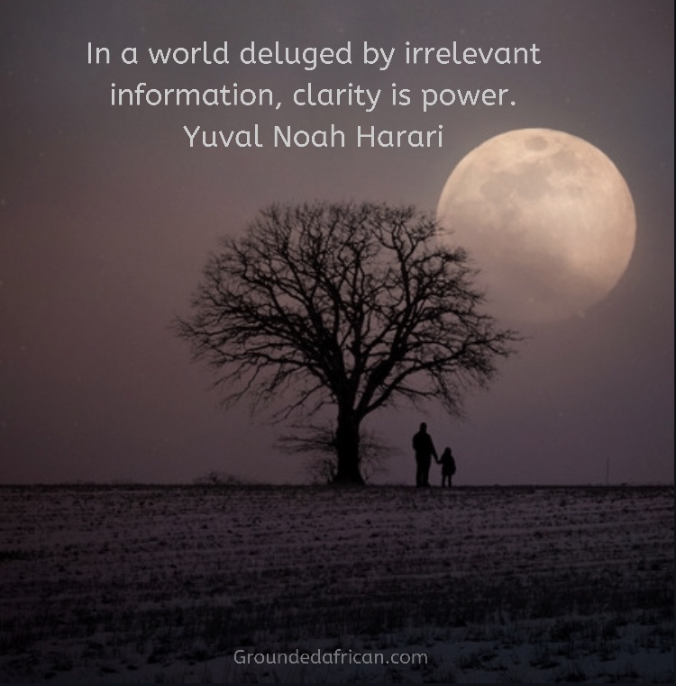 Man and child under bare tree in fallow field watching moon rising.