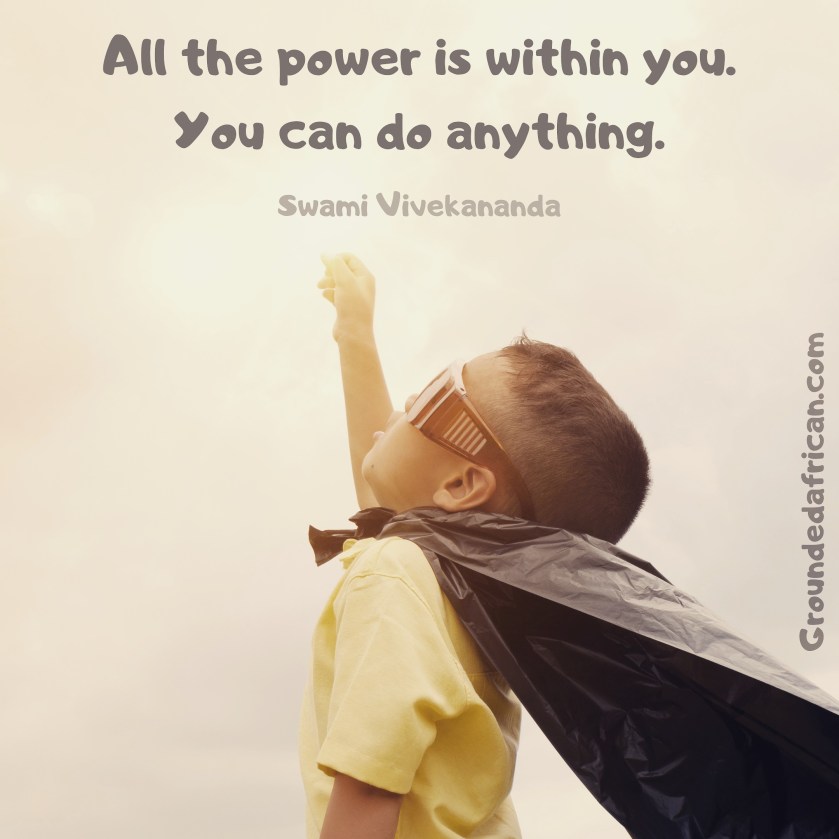 Little boy with packet cape and toy glasses in Superman fist pose