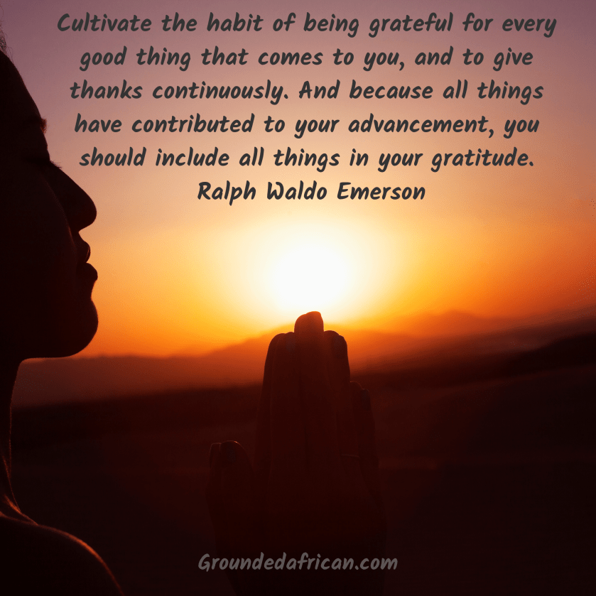 Silhouette of person praying before the rising sun