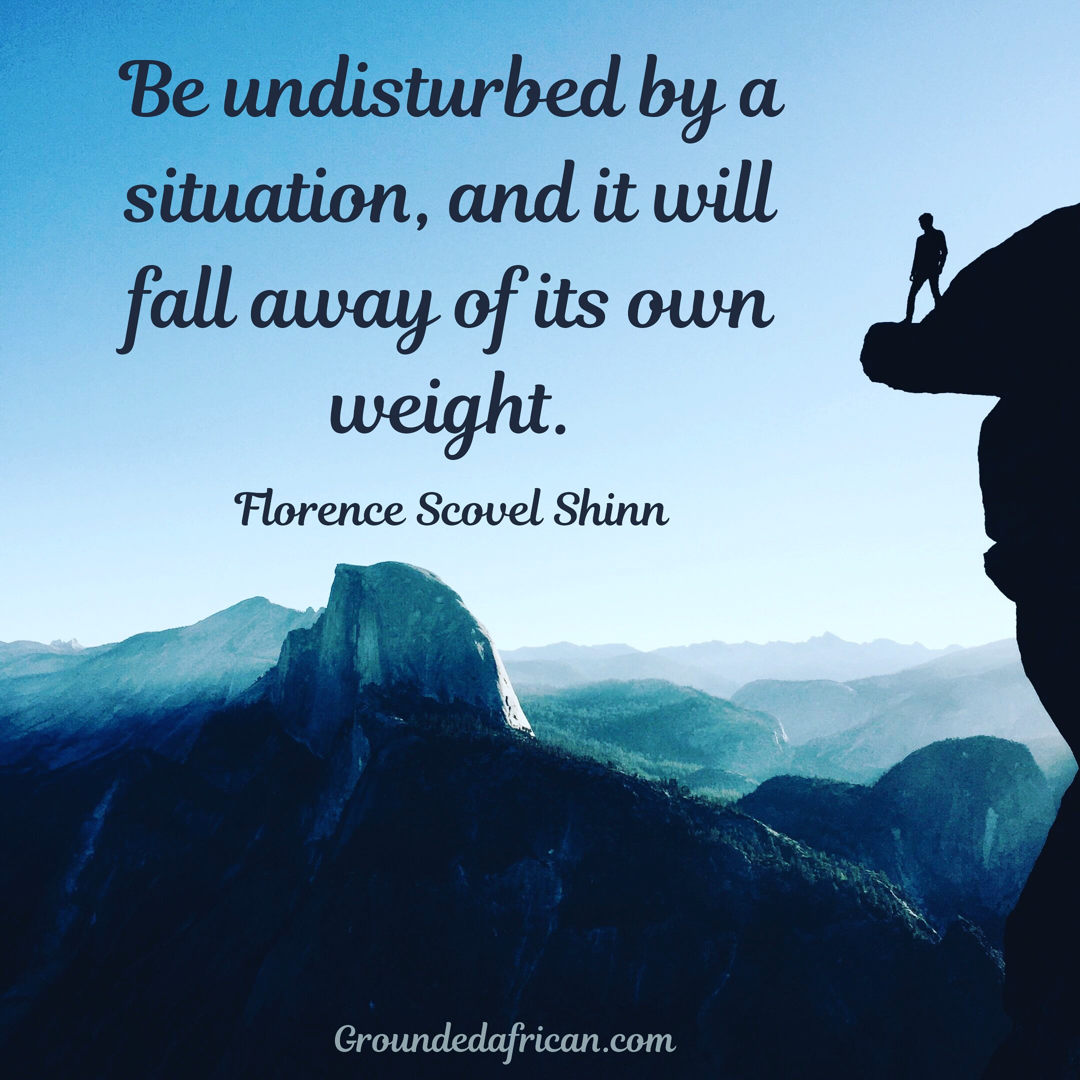 Man on ledge overlooking misty mountainous area 