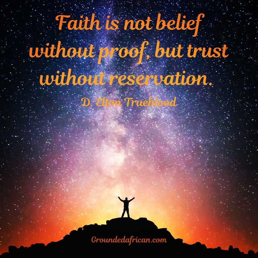 Man with arms raised to the night sky. Backlit by a fire below him