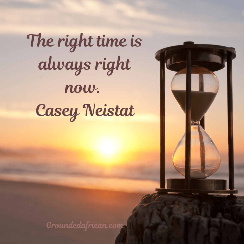 Timer on rock overlooking sea with rising sun in background 